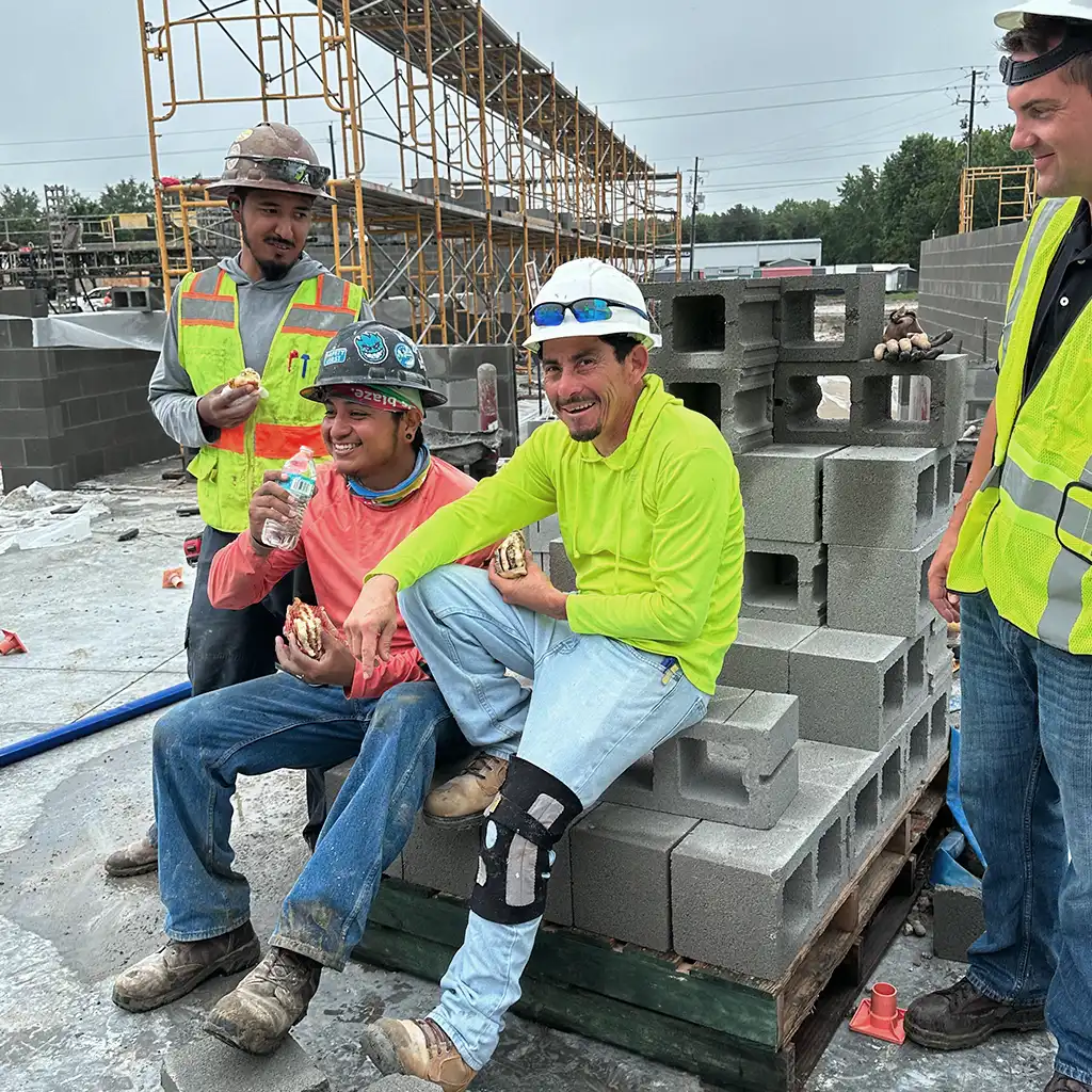 Construction workers at a job site having a snack.